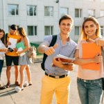 happy-two-young-students-with-note-books-and-backpacks-smiling-and-showing-thumb-up-1-scaled.jpg